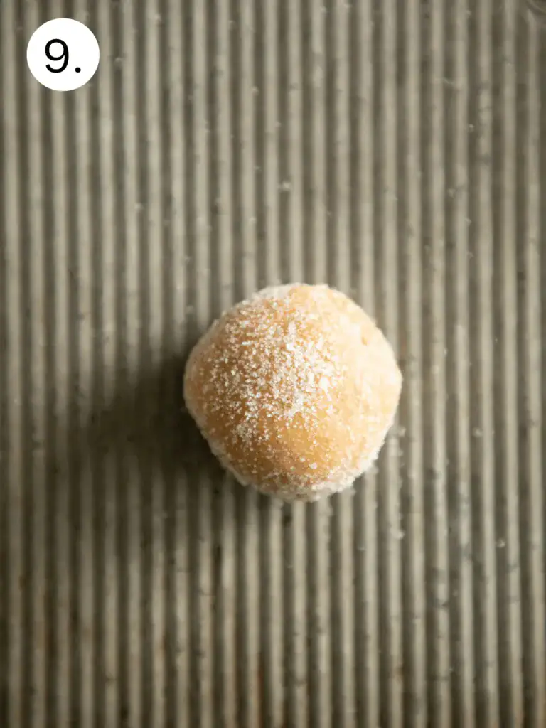 Unbaked peanut butter cookie dough ball coated in sugar, ready to bake (Image 9)