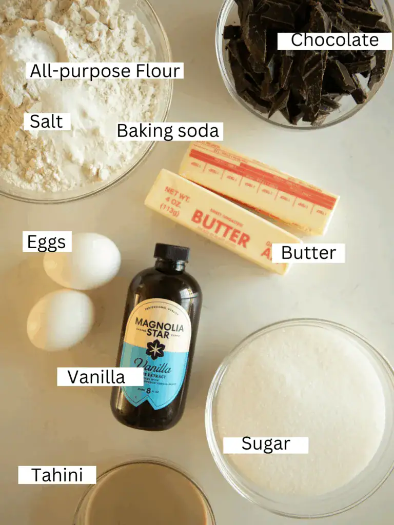 Flatlay of tahini cookie ingredients including butter, vanilla, and eggs.