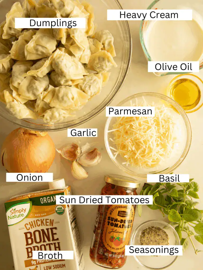 Top-down view of labeled ingredients for marry me baked dumplings including dumplings, cream, parmesan, and sun-dried tomatoes.