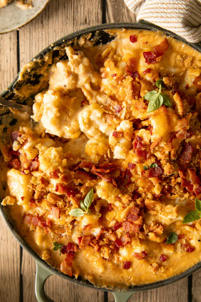 skillet with fresh baked cauliflower casserole topped with fresh herbs