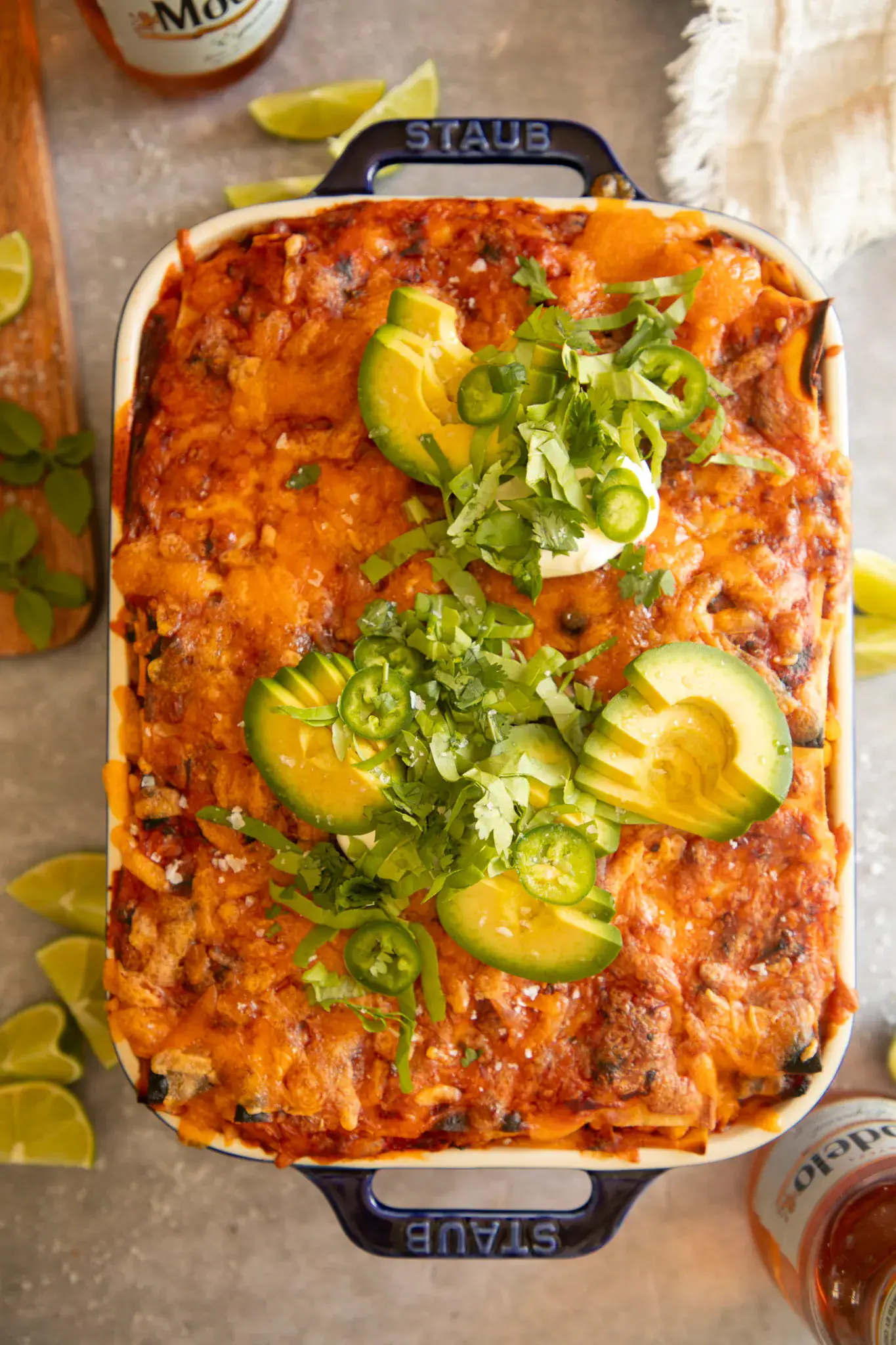 Overhead shot of baked Mexican lasagna topped with fresh garnishes, ready to serve.