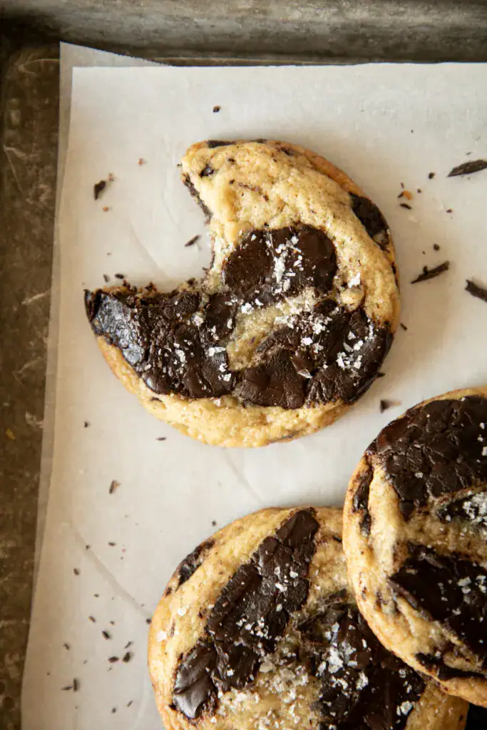 Baked tahini chocolate chunk cookies sprinkled with flaky salt.