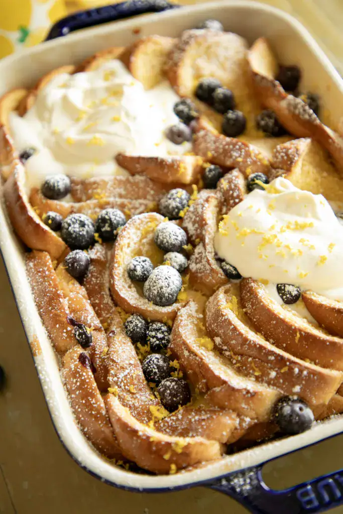 baked French toast toped with a dollop of whipped cream and lemon zest