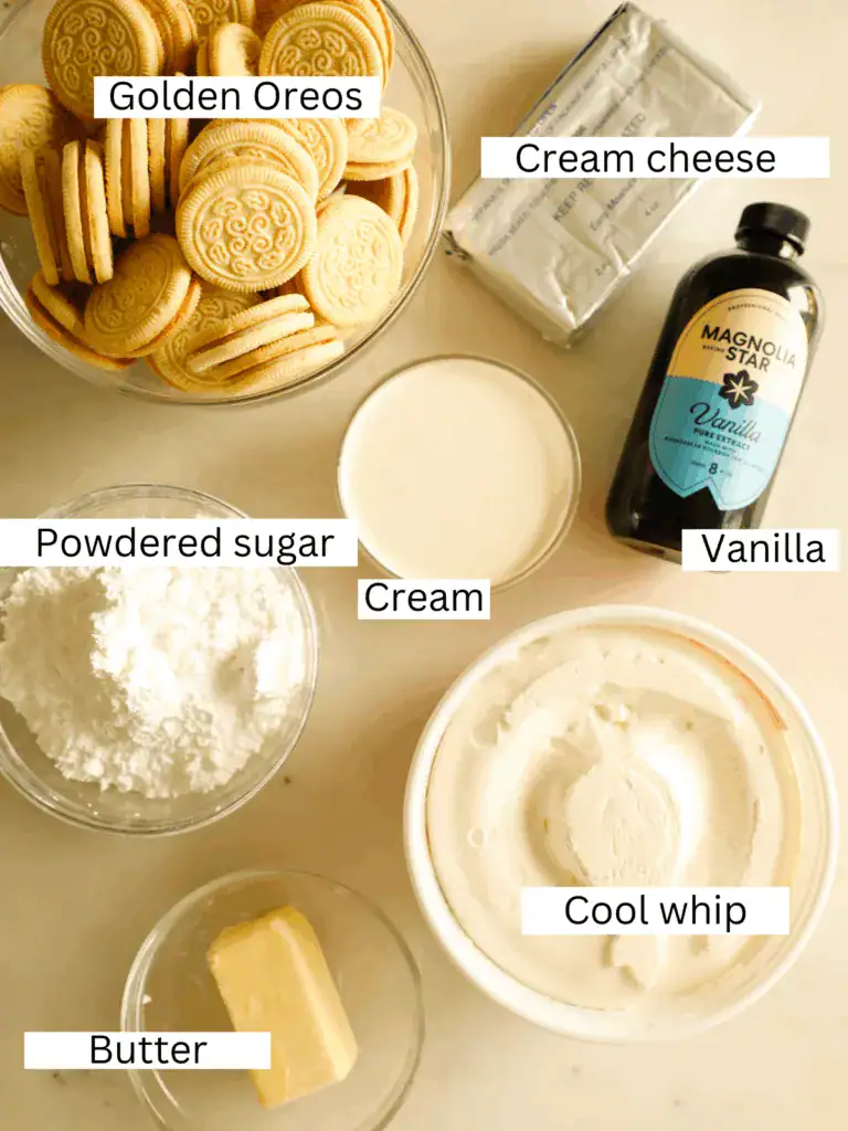 Overhead shot of Golden Oreos, cream cheese, powdered sugar, butter, vanilla, heavy cream, and Cool Whip laid out on a white surface