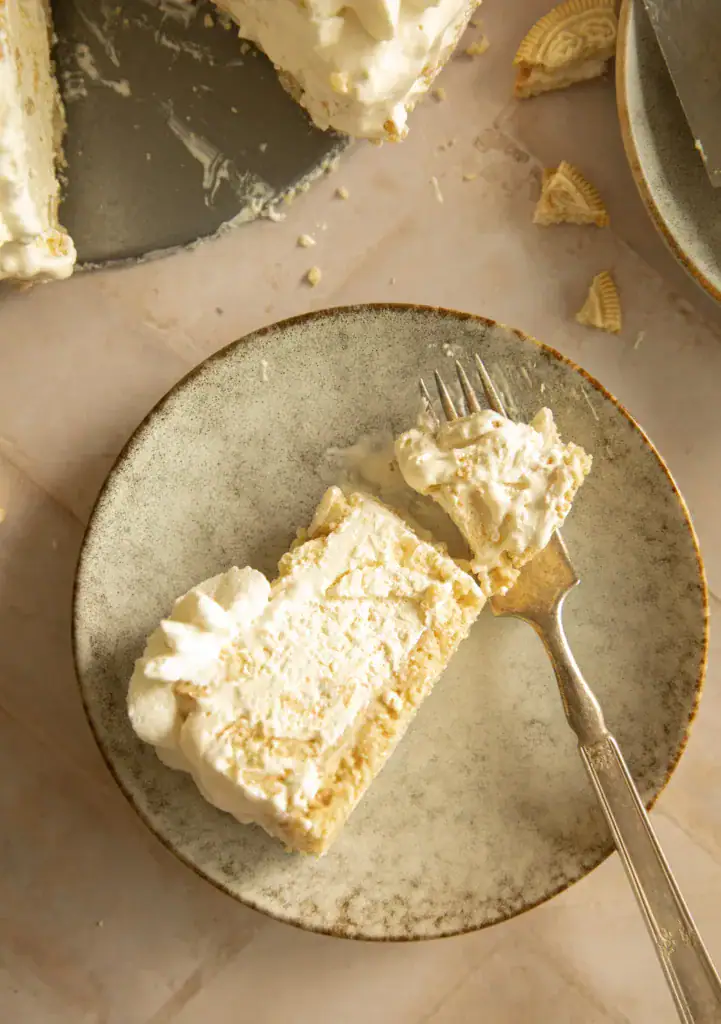 Close-up of a slice of frozen Oreo pie on a speckled plate with a fork, showing the creamy texture and crust