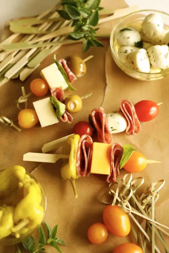 Overhead flat lay of assorted antipasto skewers laid out for a party appetizer spread.