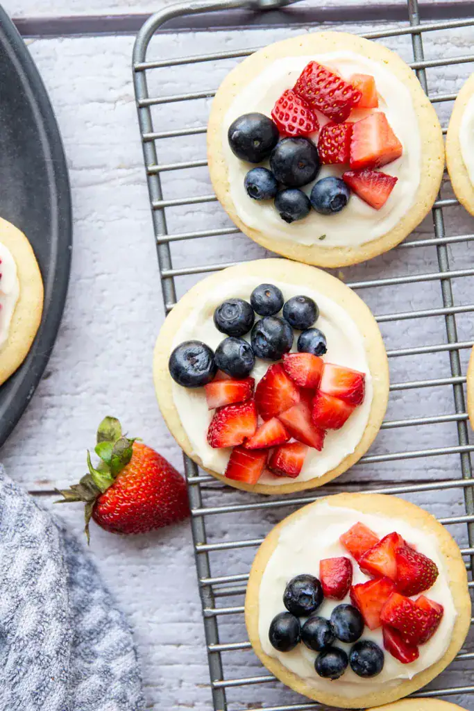 mini fruit pizzas on a wire rack with strawberries