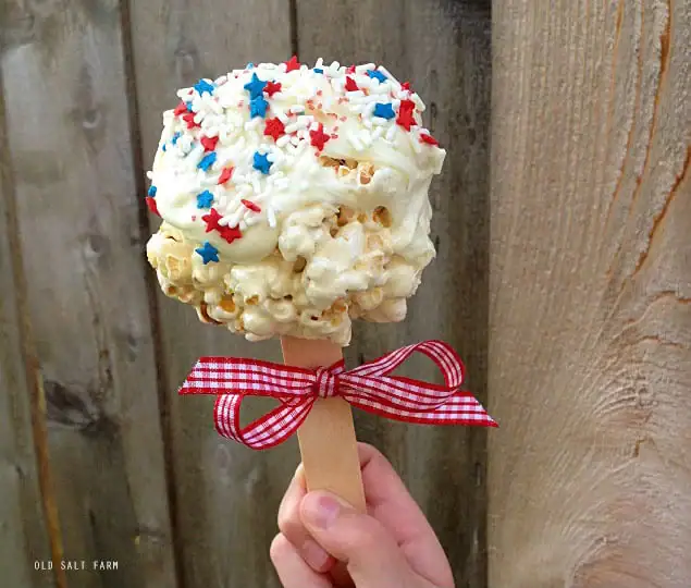 popcorn ball on a posicle stick with ribbon