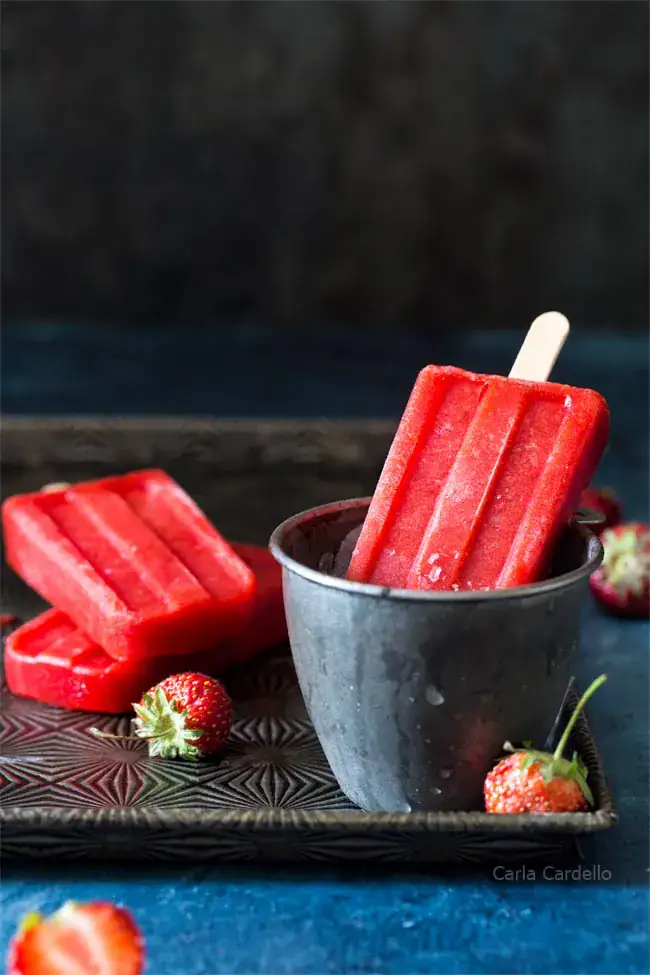 red popsicles on a black background