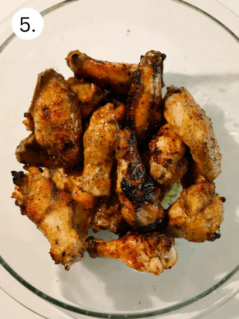Charred grilled wings just off the grill, ready to be tossed in sauce