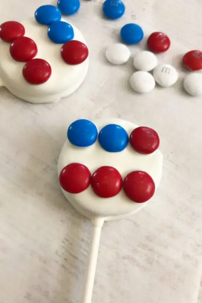 oreos dipped in white chocolate with red and blue M&Ms making a flag shape