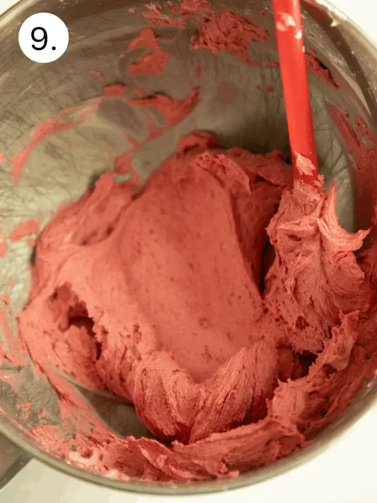 Bowl of pink buttercream frosting used to fill the funfetti shortbread cookie sandwiches.