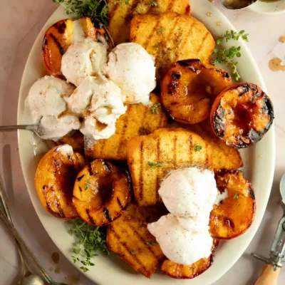 Overhead shot of grilled peaches and pound cake with melted vanilla ice cream on top.