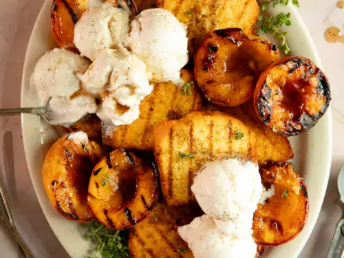 Overhead shot of grilled peaches and pound cake with melted vanilla ice cream on top.