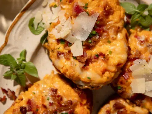 Twice baked sweet potatoes topped with white cheddar, bacon, and chives, served with sour cream.