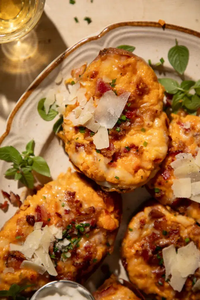 Twice baked sweet potatoes topped with white cheddar, bacon, and chives, served with sour cream.