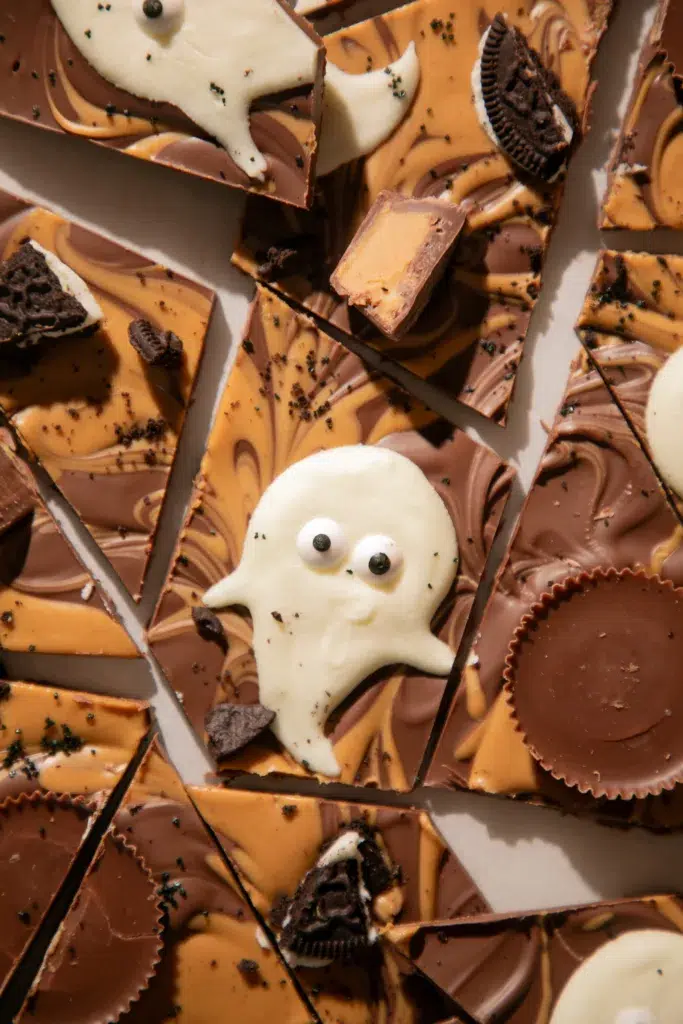 Close-up of ghost-shaped white chocolate on peanut butter chocolate bark with candy eyes.