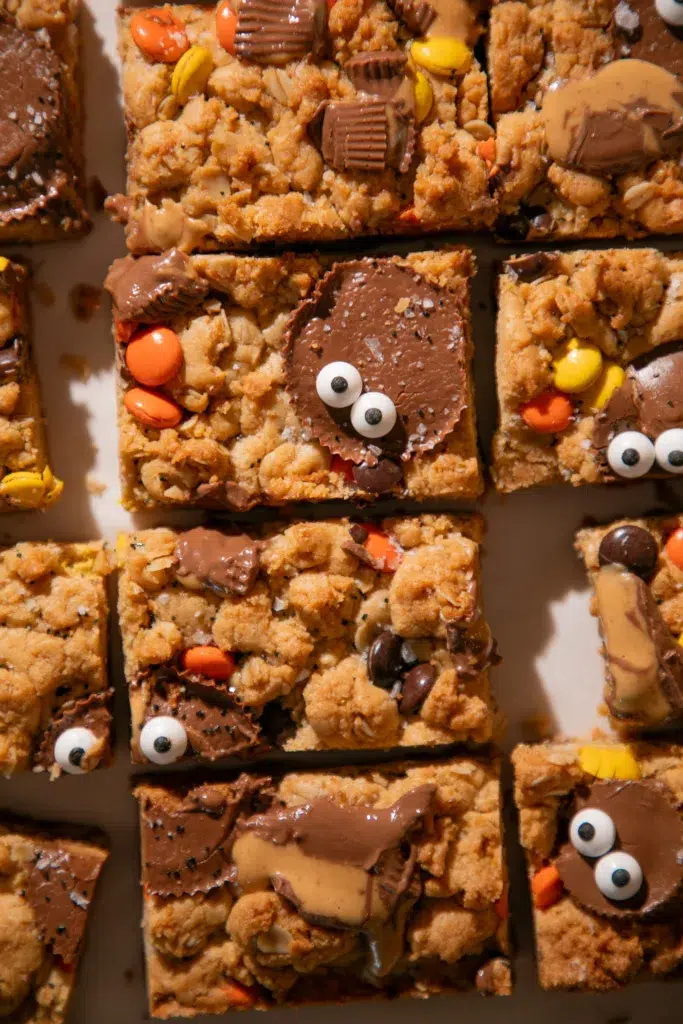 Close-up of a Halloween Monster Cookie Bar topped with a Reese’s Cup and candy eyes.