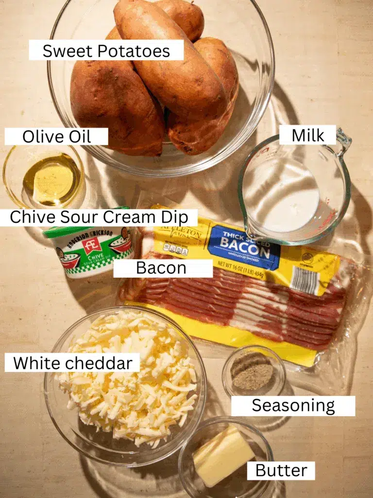 Ingredients for White Cheddar, Bacon, and Chive Twice Baked Sweet Potatoes including sweet potatoes, bacon, white cheddar, sour cream dip, butter, and seasonings.