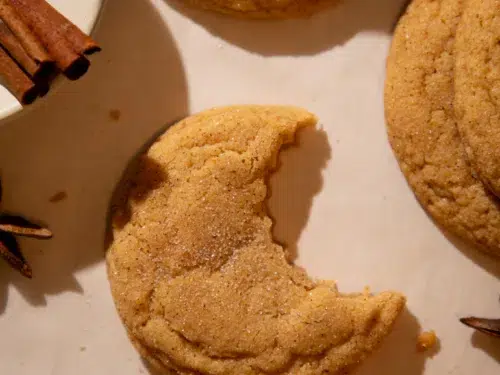 Soft pumpkin chai snickerdoodle cookie with a bite taken out, showing chewy center.