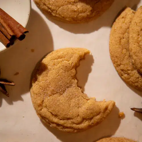 Soft pumpkin chai snickerdoodle cookie with a bite taken out, showing chewy center.