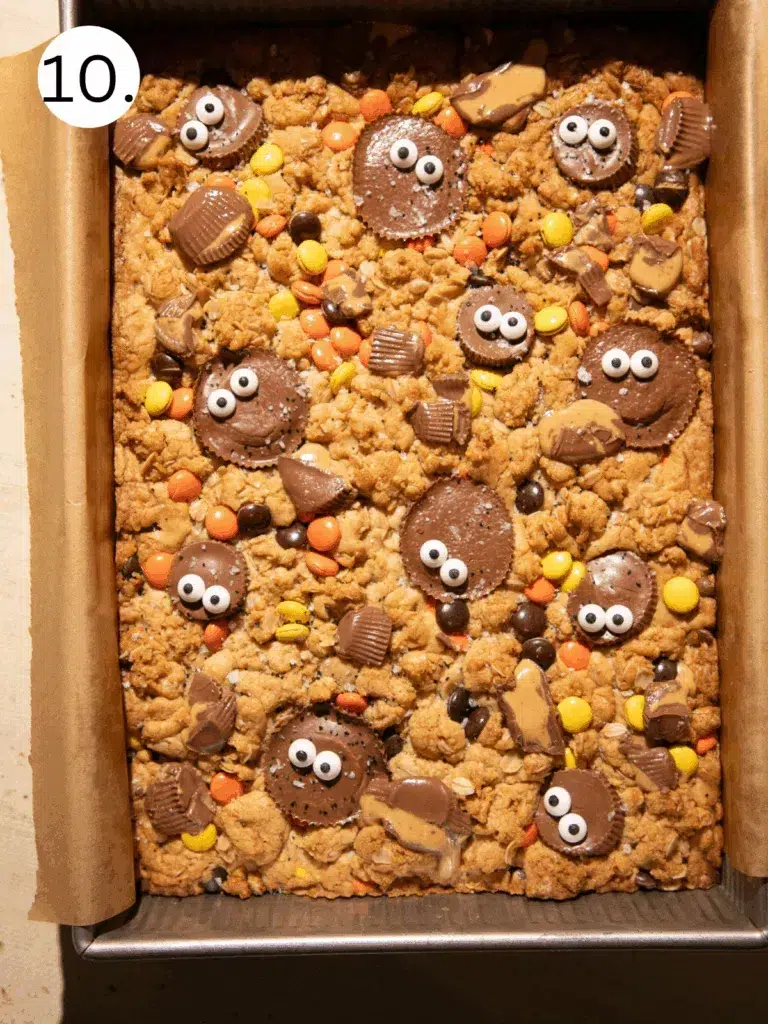 Baked Halloween Reese’s Monster Cookie Bars topped with candy eyes, Reese’s Cups, and Reese’s Pieces