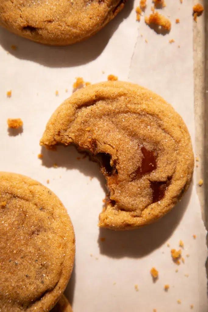 Cookie with bite taken out showing gooey melted toffee inside.