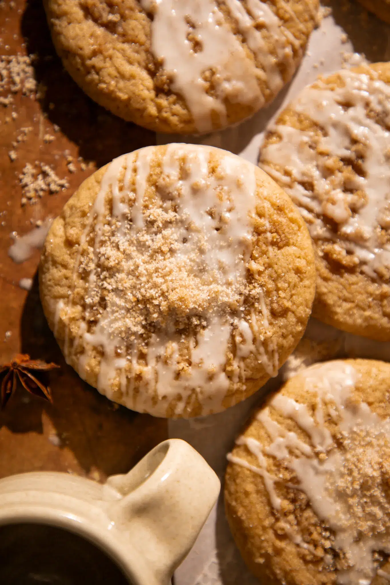 Overhead view of apple cider coffee cake cookies topped with streusel and drizzled glaze.