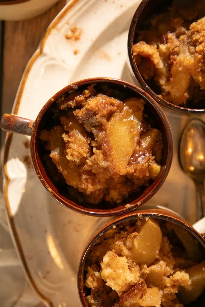 Close-up of warm apple dump cake with spiced apple filling and crumbly topping.