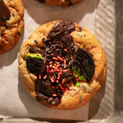 Freshly baked Halloween chocolate chip cookies loaded with Oreos, Reese’s, chocolate chunks, and sprinkles.