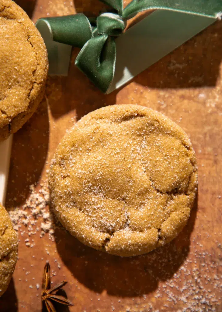 Sugar-coated molasses ginger cookie styled with a green ribbon for a festive holiday presentation.