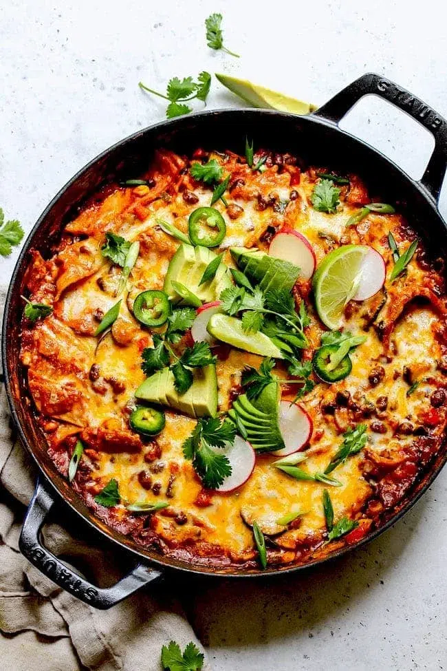 Skillet with enchiladas and fixings
