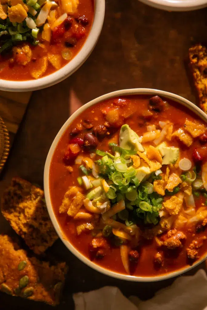 Overhead view of pumpkin turkey chili served with pumpkin cornbread on the side.