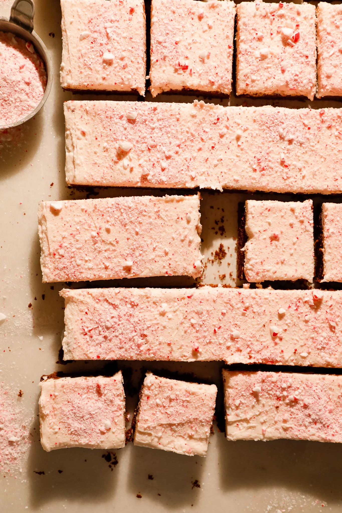 Overhead of peppermint mocha cookie bars with a cup of crushed peppermint candies, ready to serve for Christmas.