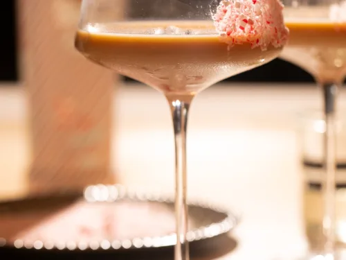 Festive peppermint espresso martini in a coupe glass with a crushed candy cane rim and creamy espresso base.