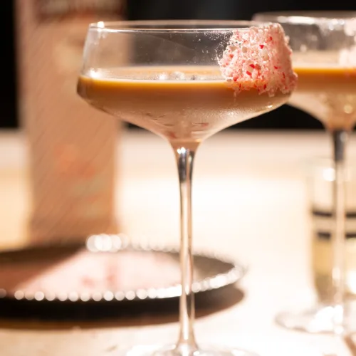 Festive peppermint espresso martini in a coupe glass with a crushed candy cane rim and creamy espresso base.
