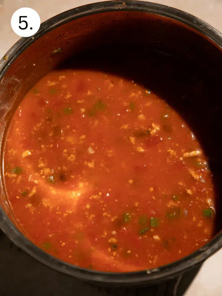 Turkey, beans, and pumpkin chili cooking in the Instant Pot before pressure cooking.
