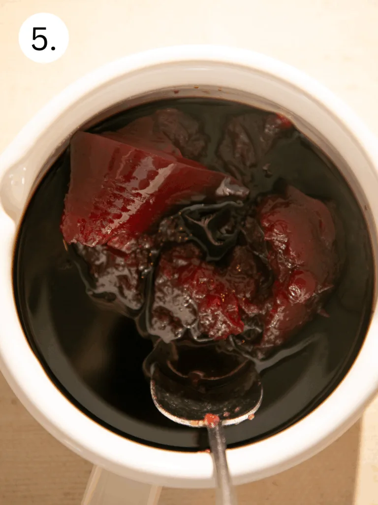 Cranberry sauce and BBQ sauce blended together in a small bowl to create a glossy, tangy glaze for homemade cocktail meatballs.