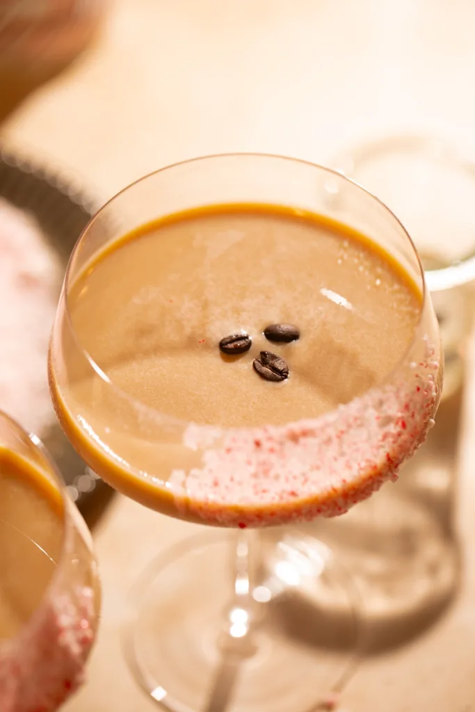 Top-down shot of a peppermint espresso martini garnished with coffee beans and a crushed peppermint rim.