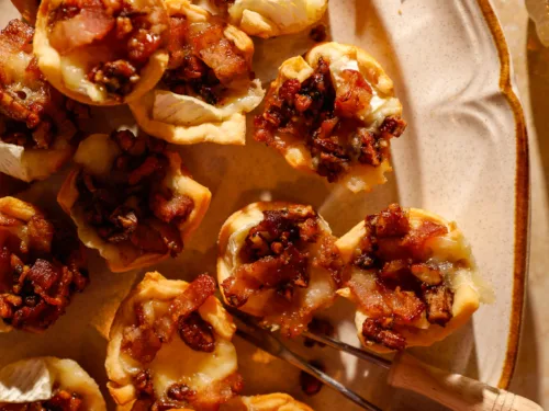 Close-up of golden crescent cups filled with melted brie, crispy bacon, and caramelized pecans.