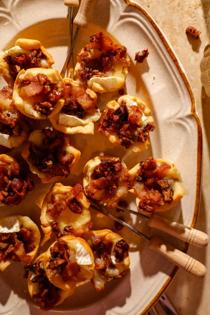 Close-up of golden crescent cups filled with melted brie, crispy bacon, and caramelized pecans.