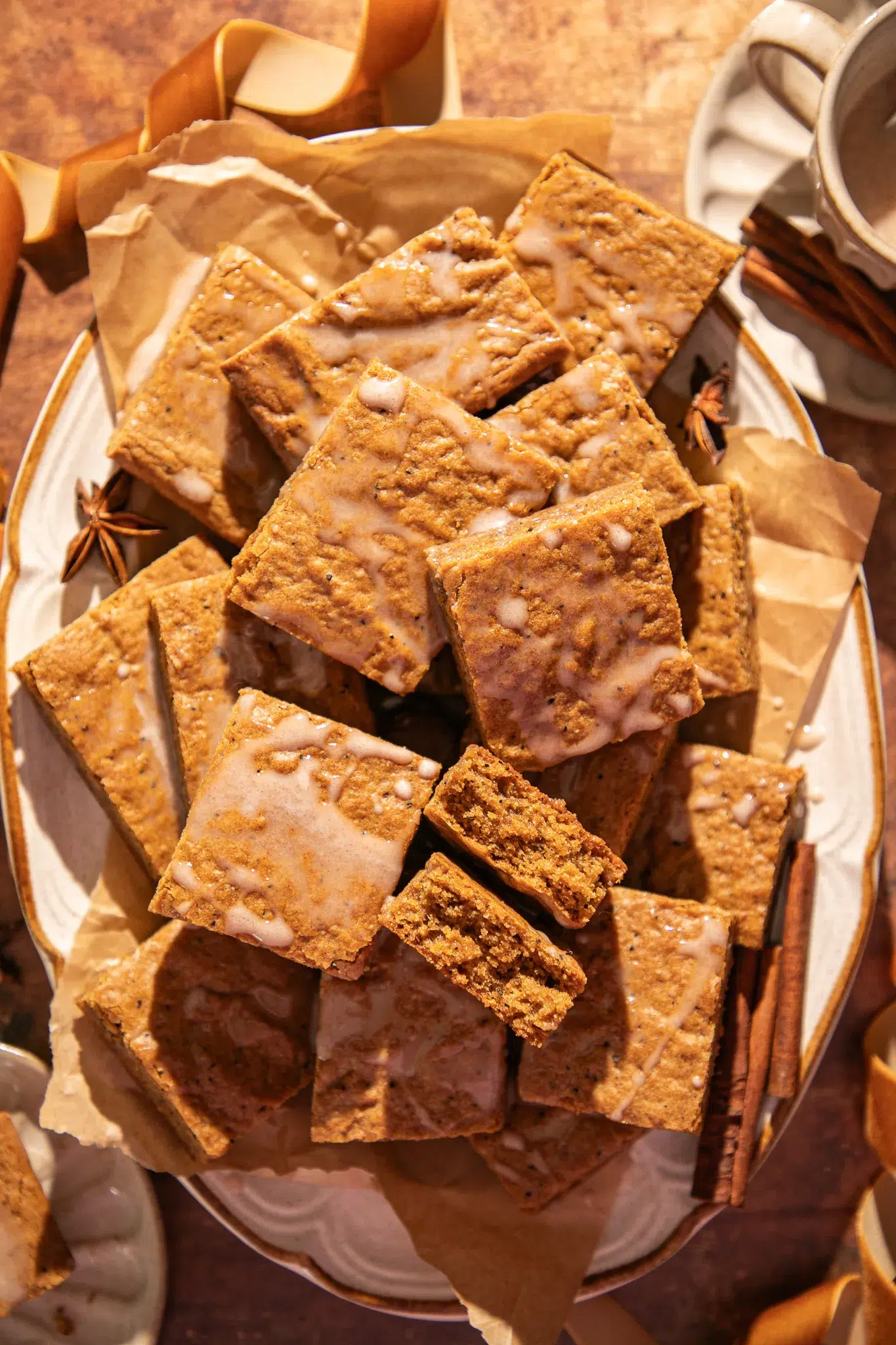 Close-up of soft gingerbread bars showing their moist texture and espresso flecks, drizzled lightly with glaze.
