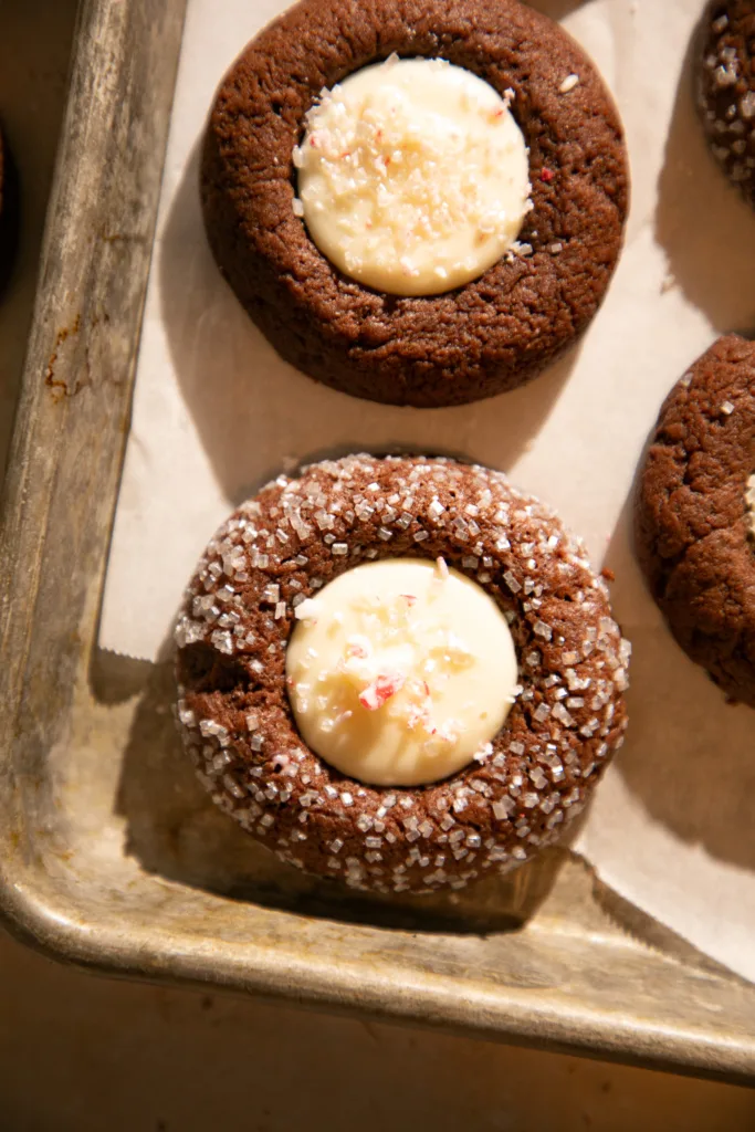 Chocolate thumbprint cookie topped with white chocolate center and crushed peppermint pieces.