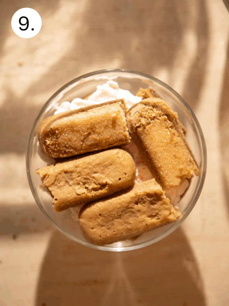 Top-down view of the second layer of espresso-soaked ladyfingers pressed into the peppermint cream mixture.