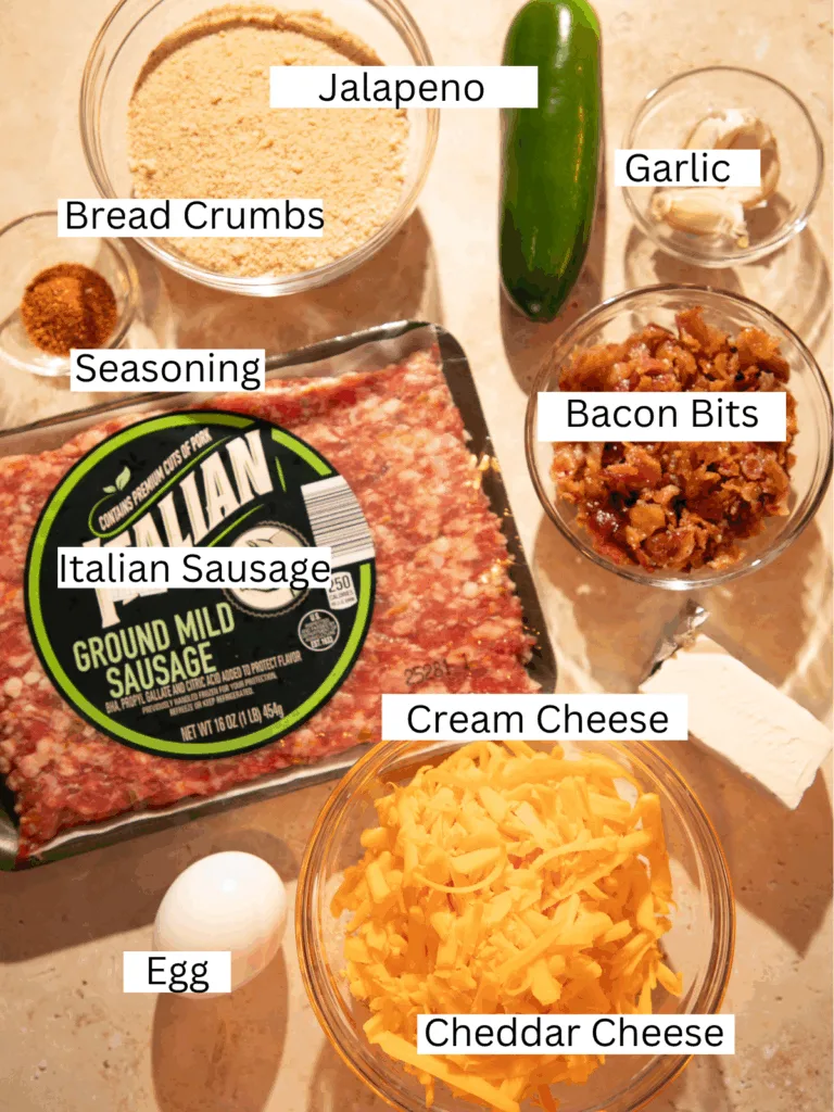 Ingredients for jalapeño popper meatballs including Italian sausage, cheddar, cream cheese, jalapeño, breadcrumbs, and bacon bits.