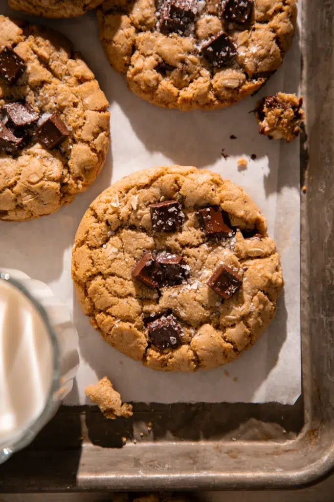 Overhead photo of a soft and chewy espresso oatmeal chocolate chunk cookie on a parchment lined tray.