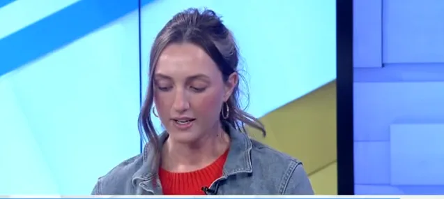 woman on tv news segment with hair up and jean jacket on