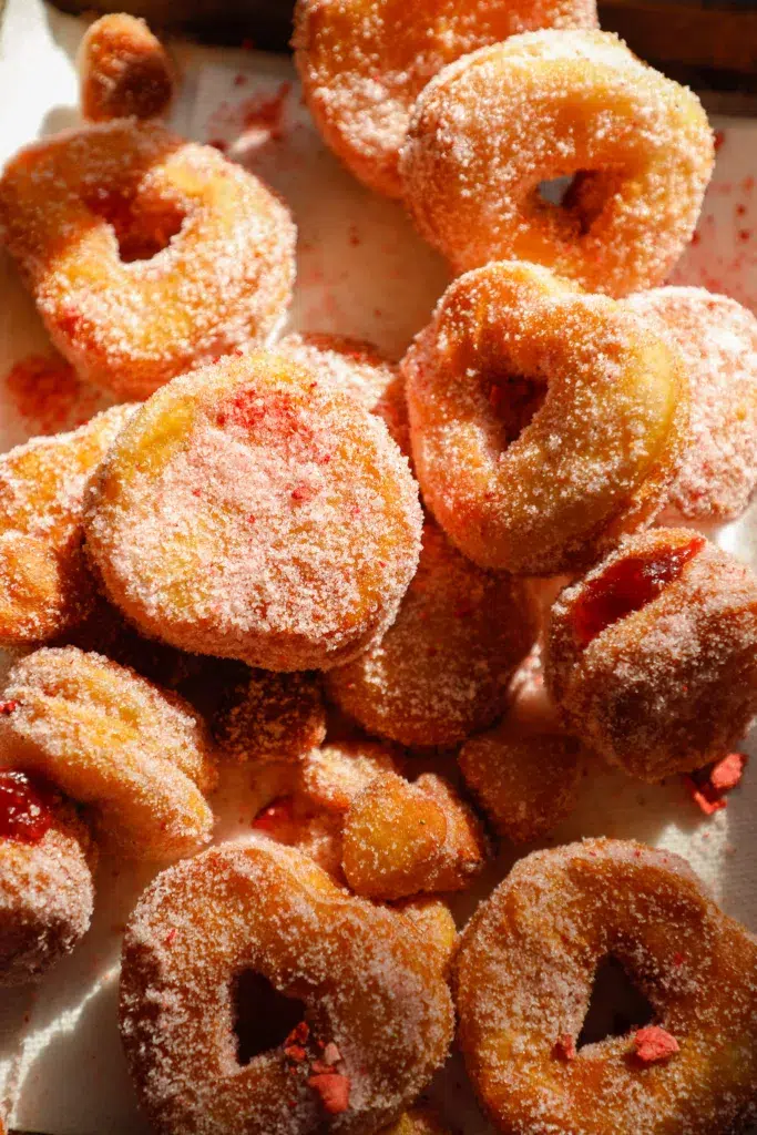 Heart-shaped biscuit donut fully coated in pink strawberry sugar.