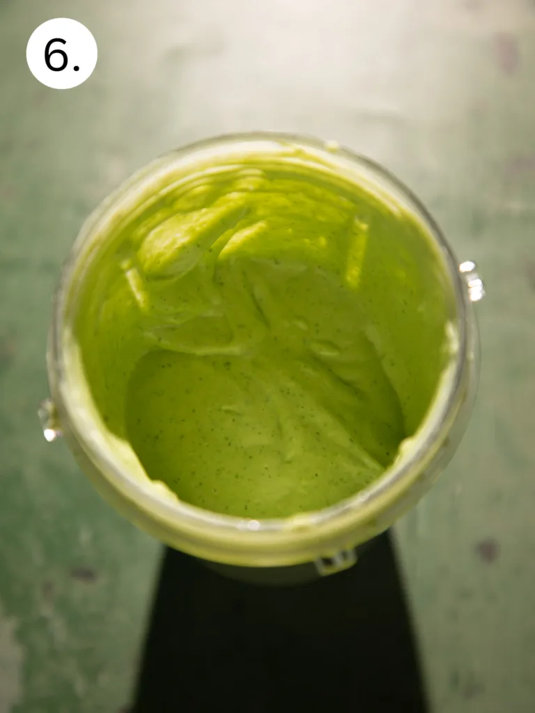 Blended cilantro lime yogurt sauce in a blender, smooth and creamy with a light green color.