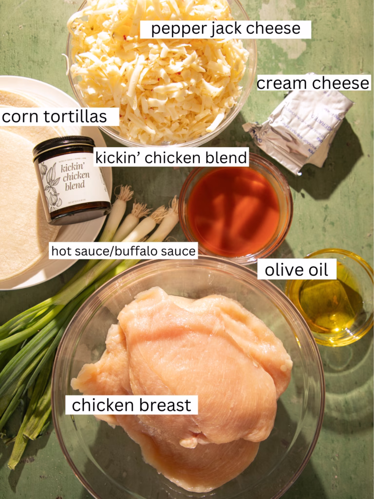 Ingredients for Nashville hot chicken taquitos including chicken breast, pepper jack cheese, cream cheese, hot sauce, and corn tortillas